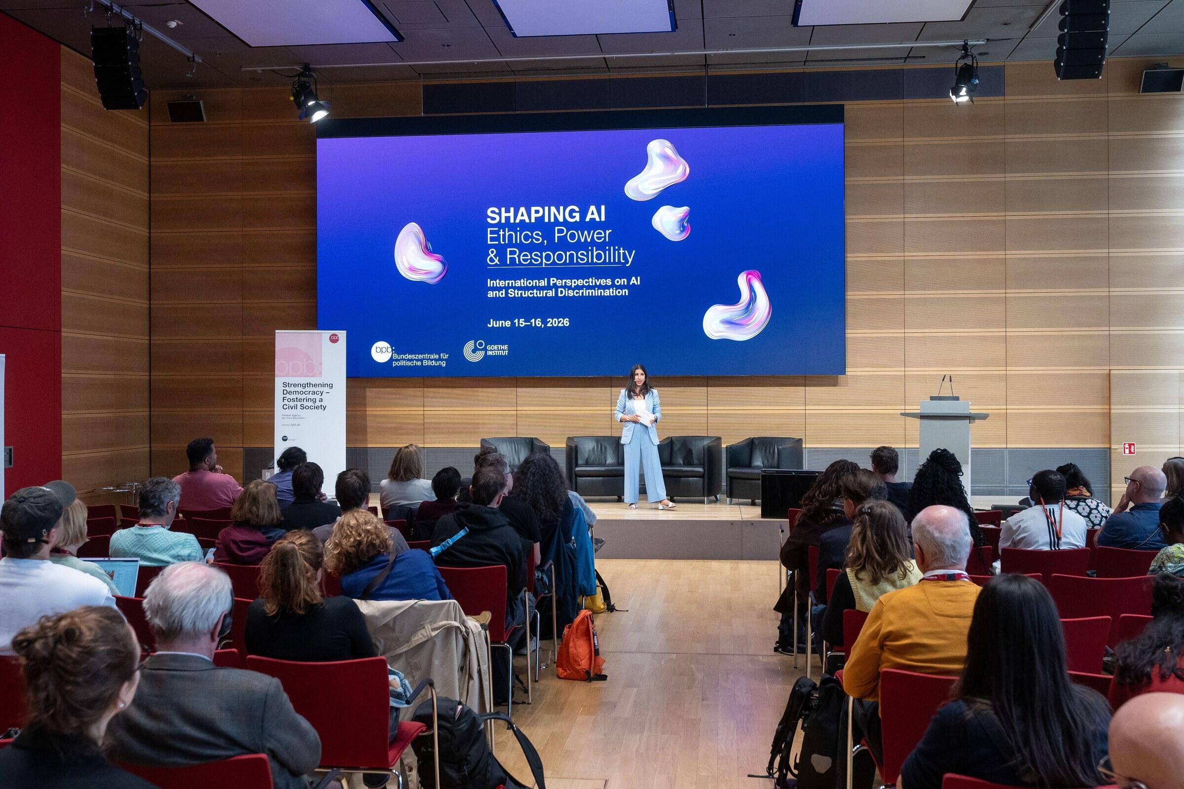 Bühne der internationalen Konferenz Shaping AI der Bundeszentrale für politische Bildung in Berlin mit Publikum im Saal